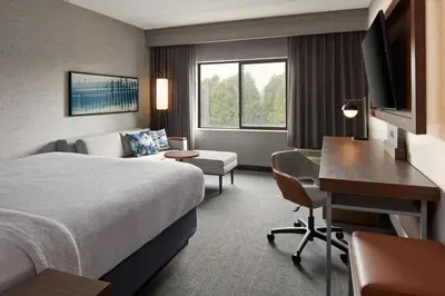 a hotel room with a bed and a desk at Courtyard by Marriott Hamilton in Hamilton