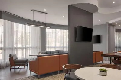 a living room with a couch and a tv at Courtyard by Marriott Mississauga-Airport Corporate Centre West in Mississauga