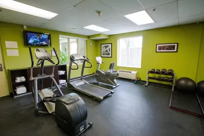 a gym with exercise equipment in a room with green walls at Fairfield Inn by Marriott Toronto Oakville in Oakville