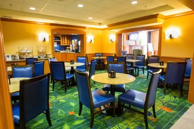 a dining room with tables and chairs and yellow walls at Fairfield Inn by Marriott Toronto Oakville in Oakville