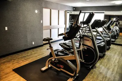 a row of cardio machines in a gym at Residence & Conference Centre - Kitchener-Waterloo in Kitchener