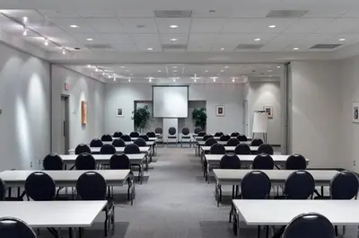 a conference room with tables and chairs and a screen at Residence & Conference Centre - Toronto in Toronto