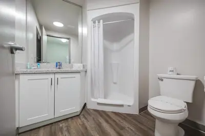 a white bathroom with a toilet and a shower at Residence & Conference Centre - Brampton in Brampton