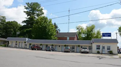 a gas station with cars parked in front of it at Bracebridge Inn in Bracebridge