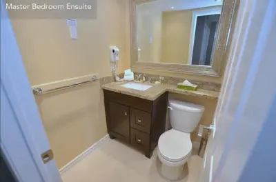 a bathroom with a toilet and a sink and a mirror at Large modern ground floor condo at Mountain Walk in Blue Mountains