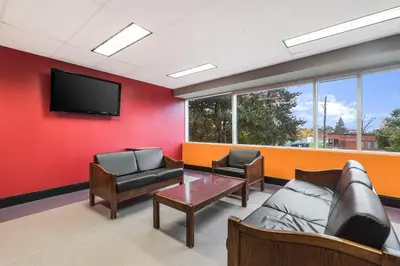 a waiting room with two couches and a flat screen tv at Residence & Conference Centre - Hamilton in Hamilton