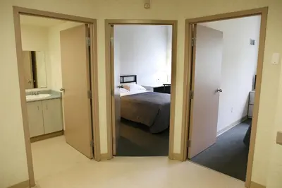 a view of a bedroom with a bed and a mirror at Residence & Conference Centre - Hamilton in Hamilton