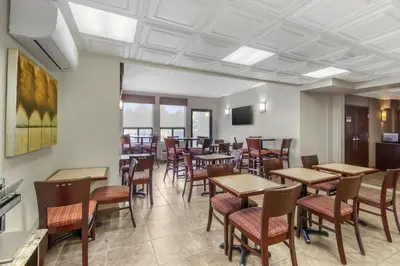 a dining room with wooden tables and chairs at Best Western Plus Rose City Suites in Welland