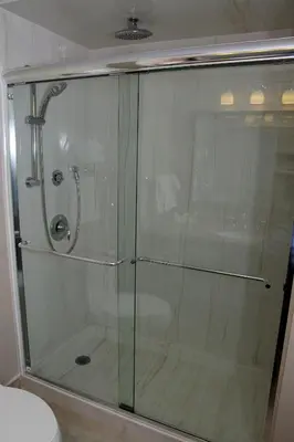 a glass shower in a bathroom with a toilet at Visitor's Inn in Hamilton