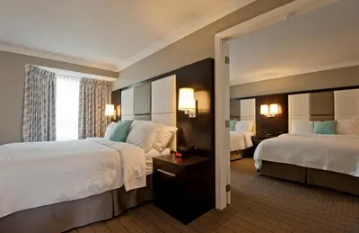 a hotel room with two beds and a mirror at Visitor's Inn in Hamilton