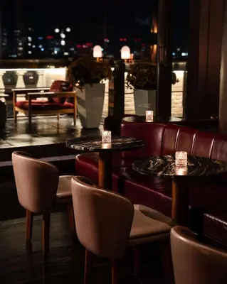 a restaurant with tables and chairs and a view of the city at Park Hyatt Toronto in Toronto