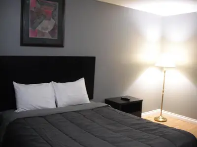 a bedroom with a bed and a lamp and a picture at Eastwood Motel in Woodstock