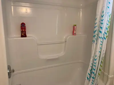 a white bath tub with a shower curtain in a bathroom at Susan's Villa in Niagara Falls