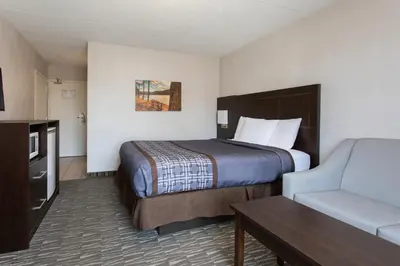 a hotel room with a bed and a couch at Super 5 Inn in Mississauga