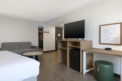 a hotel room with a bed and a flat screen tv at Spark by Hilton Toronto Mississauga in Mississauga