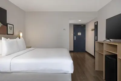 a hotel room with a bed and a flat screen tv at Spark by Hilton Toronto Mississauga in Mississauga