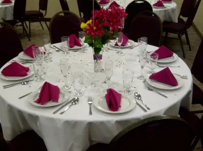 a table with pink napkins and a vase of flowers on it at Days Inn by Wyndham Brampton in Brampton