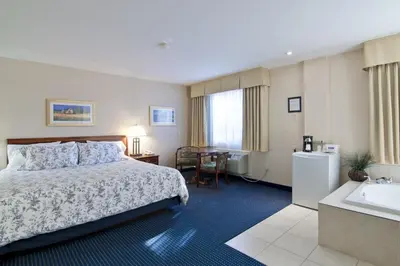 a hotel room with a bed and a sink at Travelodge by Wyndham Trenton in Trenton