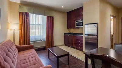 a living room with a couch and a kitchen at Best Western Plus Bowmanville in Bowmanville