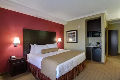 a hotel room with a large bed and red walls at Best Western Plus Bowmanville in Bowmanville
