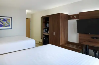 a hotel room with two beds and a flat screen tv at Holiday Inn Express Toronto Downtown by IHG in Toronto