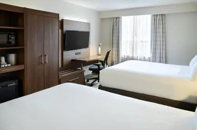a hotel room with two beds and a desk at Holiday Inn Express Toronto Downtown by IHG in Toronto