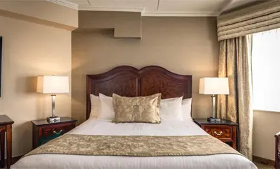 a bedroom with a large bed with two lamps at Monte Carlo Inn & Suites Downtown Markham in Markham