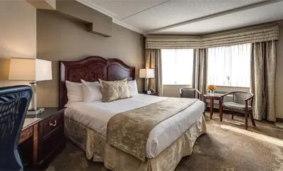 a hotel room with a large bed and a desk at Monte Carlo Inn & Suites Downtown Markham in Markham