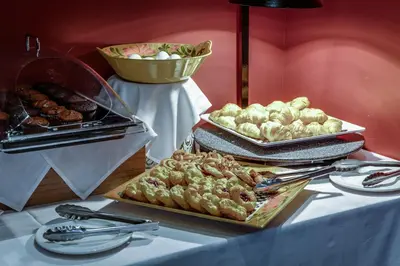 a buffet of food on a table with plates of food at Monte Carlo Inn & Suites Downtown Markham in Markham