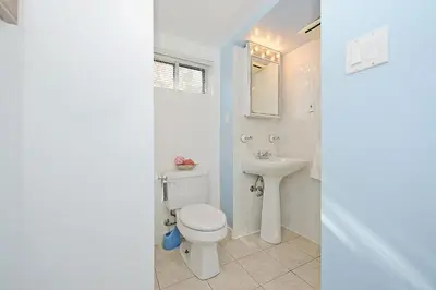 a white bathroom with a toilet and a sink at Richview Gardens Apartment in Toronto