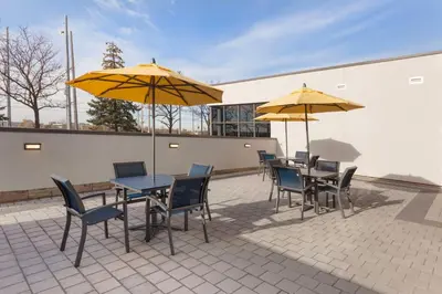 a patio with tables and chairs and umbrellas at GLō Best Western Mississauga Corporate Centre in Mississauga