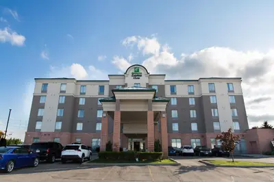 a large building with cars parked in a parking lot at Holiday Inn Express Brampton by IHG in Brampton