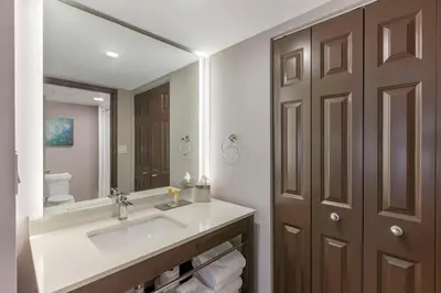 a bathroom with a sink and a large mirror at Executive Residency by Best Western Toronto-Mississauga in Mississauga
