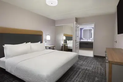 a hotel room with a large white bed and a desk at Homewood Suites by Hilton Toronto Vaughan in Vaughan