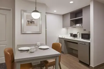 a kitchen with a table and chairs and a kitchen with a counter at Homewood Suites by Hilton Toronto Vaughan in Vaughan