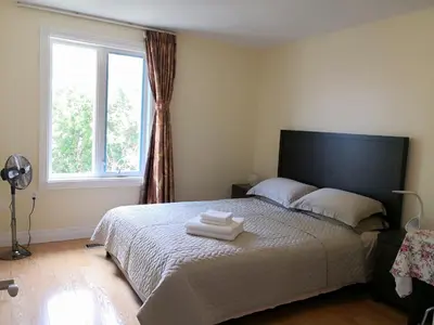 a bedroom with a bed with two towels on it at Dairy Homestay in Toronto