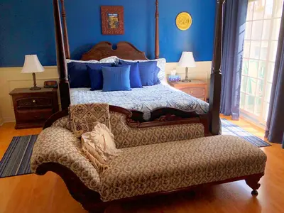 a bedroom with a bed and a couch and a chair at Butler Creek House in Niagara on the Lake