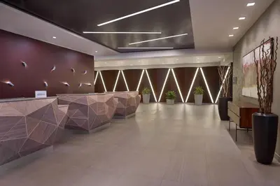 a lobby with a waiting area with tables and potted plants at TownePlace Suites by Marriott Oshawa in Oshawa