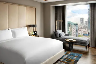a bedroom with a bed and a chair and a window at The Ritz-Carlton, Toronto in Toronto