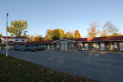 a building with cars parked in a parking lot at Kings Inn Orillia in Orillia