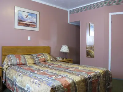 a bedroom with a bed in a room with pink walls at Kings Inn Orillia in Orillia