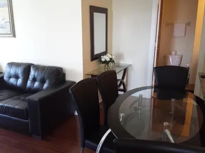 a living room with a glass table and black chairs at 2 BEDROOM 2 Bathroom Best Value Prime Location in Missisauga in Mississauga