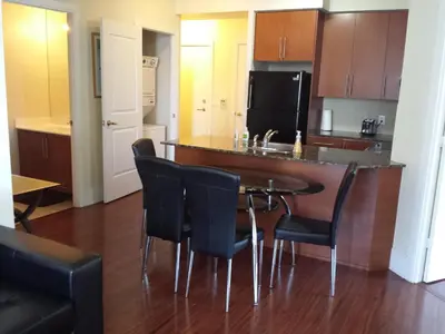 a kitchen with a bar with chairs and a table at 2 BEDROOM 2 Bathroom Best Value Prime Location in Missisauga in Mississauga