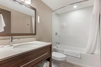 a bathroom with a sink and a toilet and a tub at Comfort Inn in Bracebridge