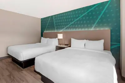 a hotel room with two beds and a green accent wall at Comfort Inn in Bracebridge