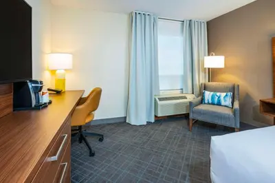 a hotel room with a bed and a desk and a chair at Comfort Inn & Suites in Ingersoll