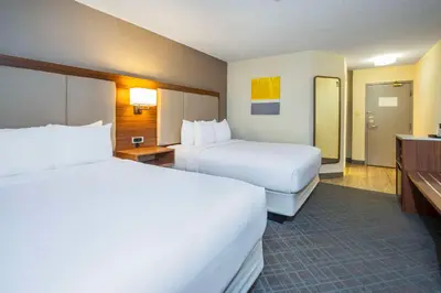 a hotel room with two beds and a bathroom at Comfort Inn & Suites in Ingersoll