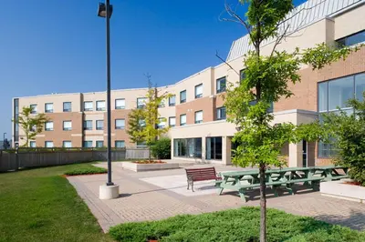 a group of picnic tables in front of a building at Residence & Conference Centre - King City in King City