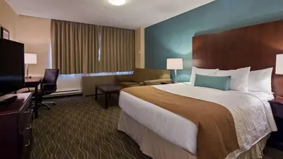 a hotel room with a large bed and a television at Best Western Plus Durham Hotel & Conference Centre in Oshawa
