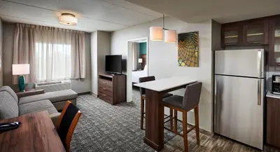 a kitchen and living room with a refrigerator and a table at Staybridge Suites Niagara-On-The-Lake by IHG in Niagara on the Lake